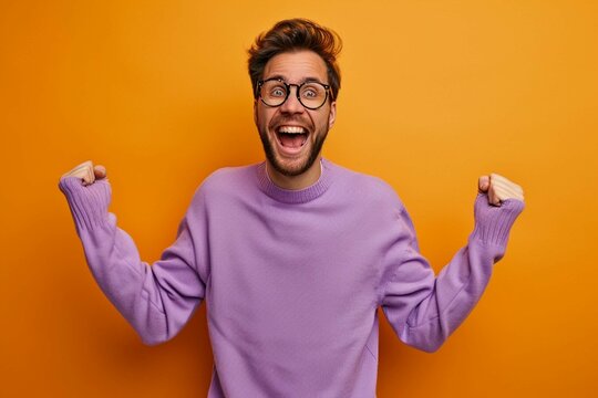 portrait of excited man in purple sweater dancing on orange background, delighted and fun person