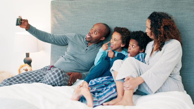African parents, selfie and children on bed, funny face and laughing together for joke, memory and happy in home. Mom, dad and kids with photography, live streaming and comic video on social media