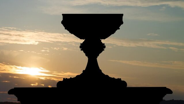 Sacred graal. or Holy grail in Silhouette at Sunrise, Time Lapse with Colorful Clouds