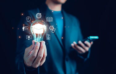 Man hand showing graduation hat icon in light bulb, Diploma, business, book, Study knowledge, Internet education course degree, student, teacher, E-learning graduate certificate program concept.