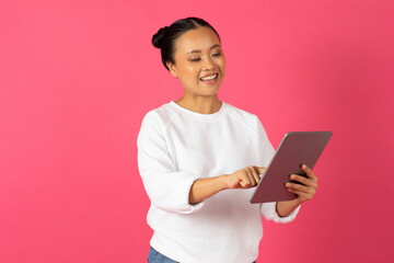 Fototapeta premium Modern Technologies. Portrait Of Young Smiling Asian Female Using Digital Tablet