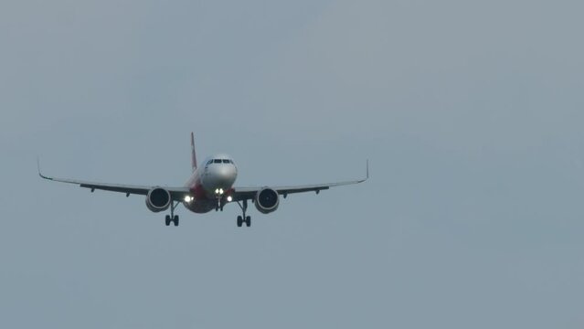 Bottom view, jet passenger plane with glowing headlights approaching landing