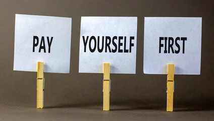 Pay yourself first symbol. Concept words Pay yourself first on beautiful white paper on clothespin. Beautiful grey table grey background. Business and pay yourself first concept. Copy space.