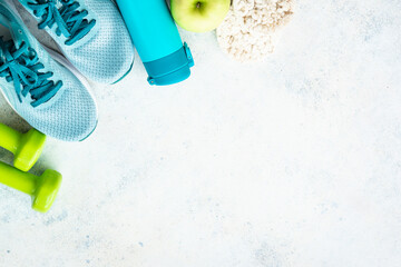Fitness equipment, flat lay image. Sneakers, dumbbells, towel and green apple. Training, workout and fitness concept. - obrazy, fototapety, plakaty