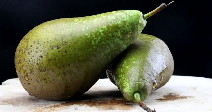 Macro video of two naturally grown green pears on a turntable