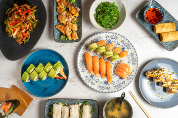 An overhead view captures a table brimming with an array of delectable Asian dishes. The rich and...