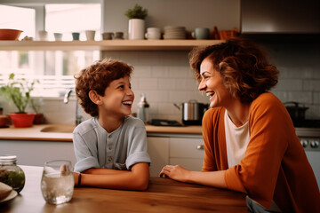 Mother and son share a cheerful moment in the kitchen, their laughter and closeness convey family warmth.