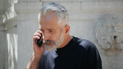 Casual senior talking cell on street closeup. Stylish mature man answering call