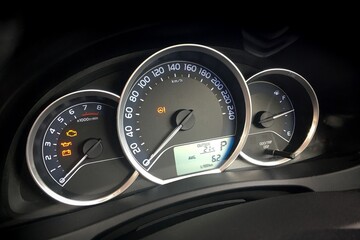 Detail of dashboard of modern car with odometer and instruments showing values as rpm and fuel...