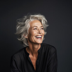 Portrait of an attractive, mature gray-haired senior woman laughing in joy