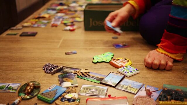 Close-up of hands with magnets and many magnets on floor