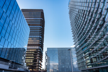 Modern office buildings that reflect other skyscrapers in Madrid in their windows.