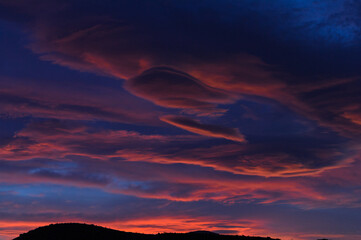 Lenticular clouds shown at twilight, dusk, during a windy evening in the Mojave Desert, California.