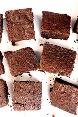 Many pieces of fresh chocolate brownie on a white table. Homemade delicious chocolate pie
