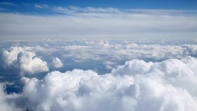 Airplane flies between layers of clouds, floccus and cumulus