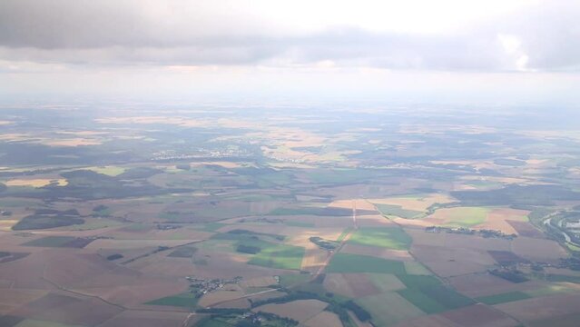 Airplane flies right under the layer of cumulus clouds.