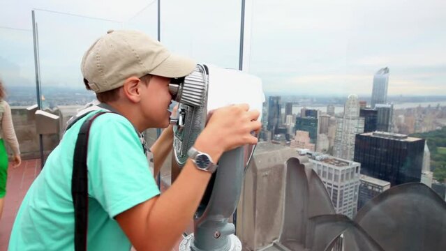 Boy looks in binocular viewer at Observation Deck Top