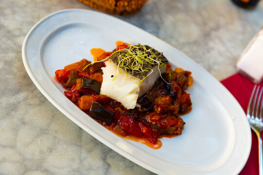Popular dish of Spanish cuisine is Bacala, made from fish with vegetables and decorated with greenery on top