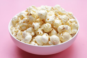 Sweet popcorn on pink background.