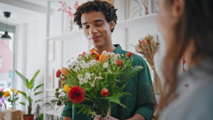 Romantic boyfriend shop flowers bouquet in shopping mall floristry store.