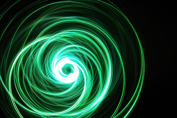 A beautiful, bright light swirl of green color. Futuristic light painting on a black background. Round light circles