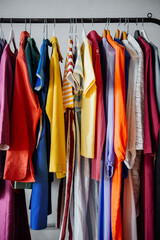 Colorful women's clothing on hangers in a retail shop. Fashion and shopping concept.
