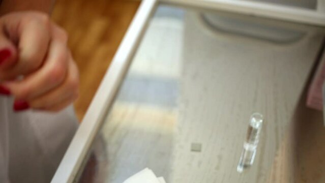 Female doctor brakes ampule head and put it on medical table.