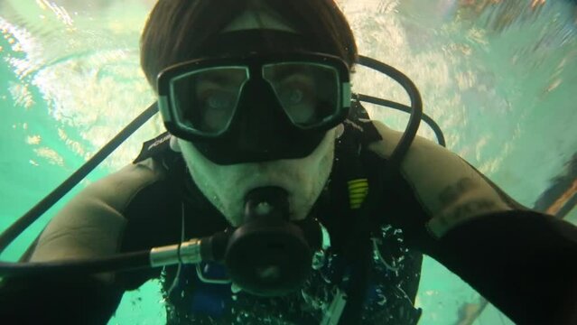 Close up view of swimming man with special equipment diving in pool