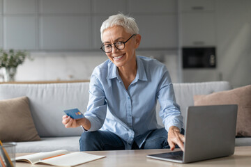 woman shopping making transaction via credit card and laptop indoor