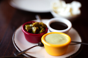 Set of three sauces on wooden table