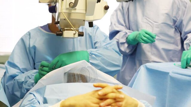 Hands of doctor and nurse during ophthalmic surgery