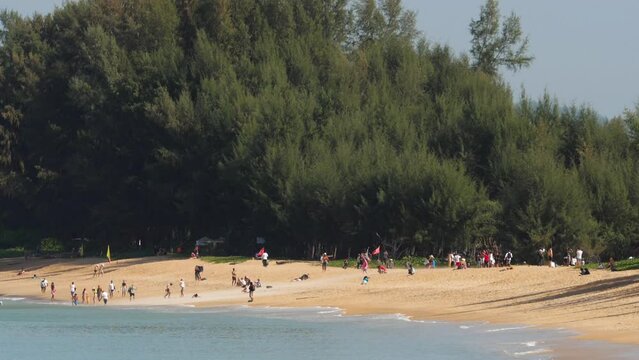Onlookers and vacationers runnig from gust of wind caused by jet blast of boosting aircraft on runway. Mai Khao beach, Phuket island.