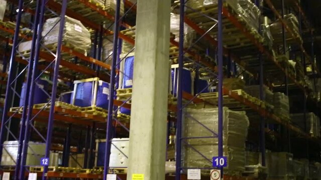 High-ceilinged storage racks with pallets of goods in warehouse.