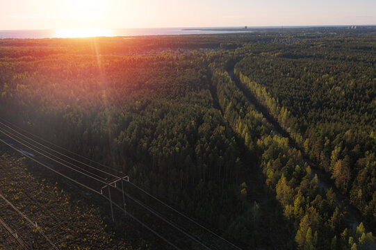 Smoking cooling towers at nuclear power plant and powerlines in forest. Sunset time.  Aerial view