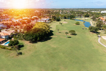 Golf club field with cart and playing golfers. Aerial view