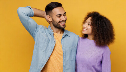 Young smiling happy couple two friends family man woman of African American ethnicity wear purple casual clothes together wife put head on shoulder isolated on plain yellow orange background studio