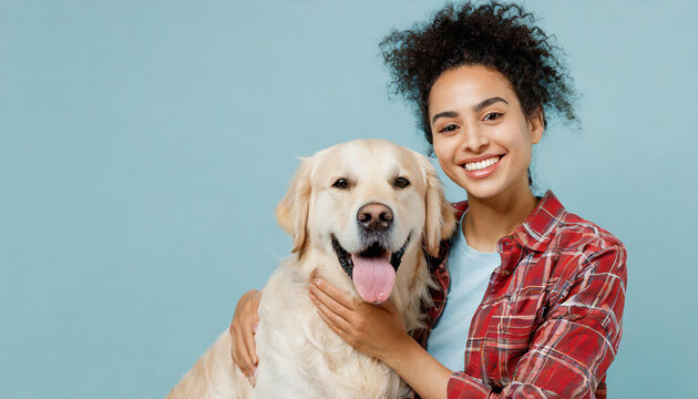 Young satisfied happy owner woman with her best friend retriever she wear casual clothes cuddle hug dog look camera isolated on plain pastel light blue background studio. Take care about pet