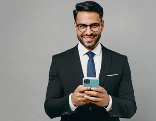 Adult happy fun successful employee business man corporate lawyer wear classic formal black suit shirt tie work in office hold in hand use mobile cell phone isolated on plain grey background studio