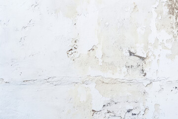 A worn white wall showing layers of old paint, significant chipping, and staining, revealing the wall's texture.
