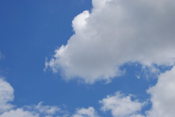 Sky landscape on a summer day. On a clear sunny day, multi-level clouds, cirrus high and cumulus low, slowly float in the light blue sky. Clouds of different shapes and sizes.