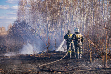 A fireman extinguishes dead wood in the spring.