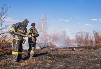 A fireman extinguishes dead wood in the spring.