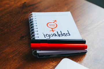 Photograph of notebook on a table with gender equality messages.