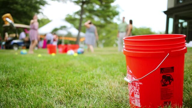 Red bucket and falling ball and playing people out of focus outdoor
