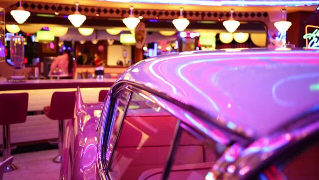 Interior of old pink car with illumination in retro restaurant