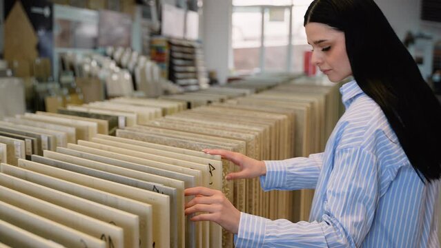 Woman browsing tile samples in home improvement store