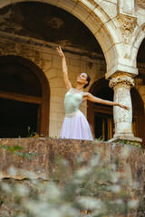 Ballet diva making figures in front of an old building with arches.