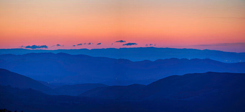 Panoramic view of silhouetted layers of mountains at sunrise, sunset