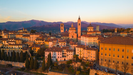 Fototapeta premium Citta Alta - Bergamo, Italy. Drone aerial view of the old town during sunrise. Landscape at the city center, its historical buildings. 