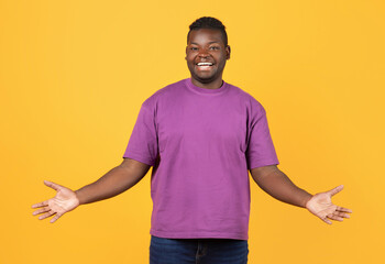 Cheerful Black Guy In Purple T-Shirt Spreading Arms, Yellow Backdrop